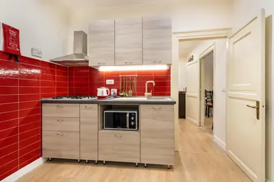 a kitchen with red tiles and a red wall at Casa Nonna Toto in Palermo