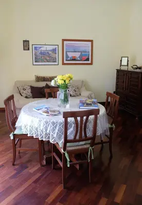 a dining room table with a vase of flowers on it at La Casa Di Tufo in Palermo