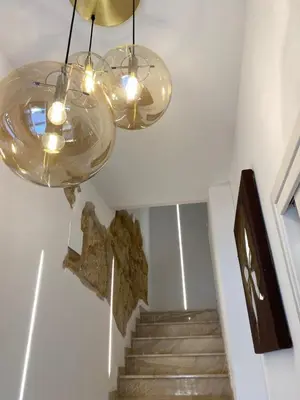 a staircase with two glass chandeliers and some rocks at Atrium in Castellammare del Golfo
