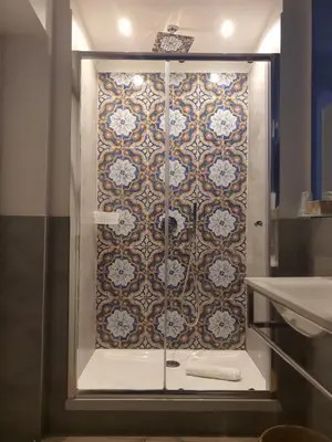 a bathroom with a shower with a tile wall at B&B Ponticello in Palermo