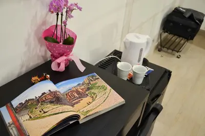 a table with a book and a vase with flowers at B&B Ponticello in Palermo