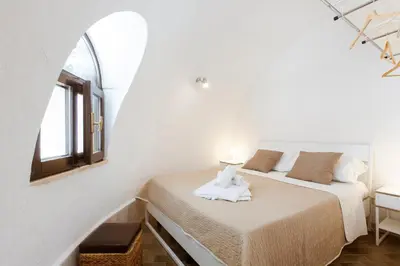 a bedroom with a bed in a white room at Residence Guidaloca in Scopello