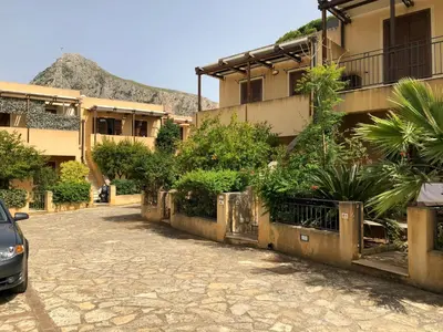 a street in front of a building with plants at casa Francy in San Vito lo Capo
