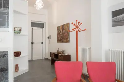 a living room with two red chairs and a pole at Casa Rosa in Palermo