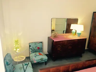 a room with a mirror and a dresser and a chair at Casa Rosa in Palermo