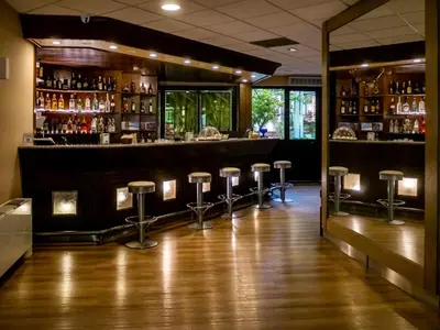 a bar with stools in the middle of a room at San Paolo Palace Hotel in Palermo