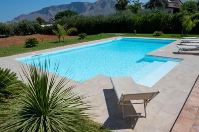 a swimming pool with a chair in a yard at Villa delle Cecilie in Partinico