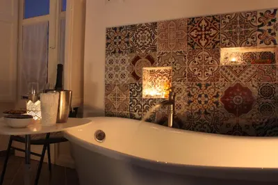 a bath tub in a bathroom with a wall at Dimore de La Rosa in Palermo