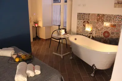 a bathroom with a bath tub and a table with towels at Dimore de La Rosa in Palermo