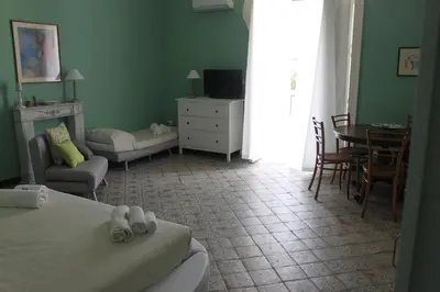 a bedroom with a bed and a table and chairs at Dimore de La Rosa in Palermo