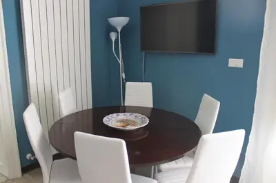 a dining room with a table and white chairs at Dimore de La Rosa in Palermo