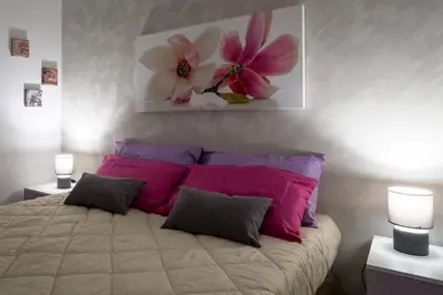 a bedroom with a bed with pink and purple pillows at Casa Petra ai Quattro Canti in Palermo