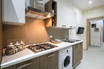 a kitchen with a stove and a washing machine at Casa Petra ai Quattro Canti in Palermo