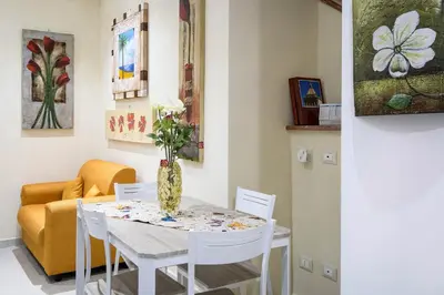 a dining room with a table with a vase of flowers on it at Casa Petra ai Quattro Canti in Palermo