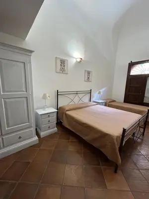 a bedroom with a bed and a chair and a window at B&B Cinisi Vacanze in Cinisi