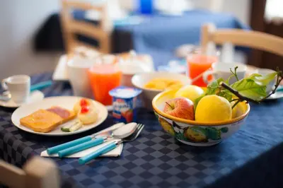 a table with a bowl of fruit and plates of food at B&B Cinisi Vacanze in Cinisi