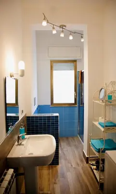 a bathroom with a white sink and blue tiles at Siciliaiu in Mondello