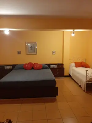 a bedroom with two beds and a tv on the wall at Lomarchi Holiday Home in Carini