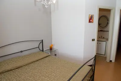 a bedroom with a bed and a chandelier at Lomarchi Holiday Home in Carini