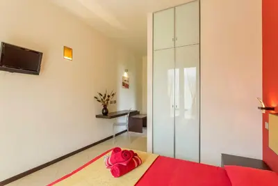 a bedroom with a bed with a red blanket at Karma B&B in San Vito lo Capo