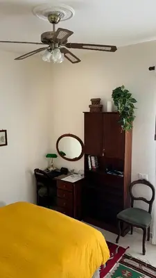 a bedroom with a yellow bed and a ceiling fan at 301B&B in Palermo