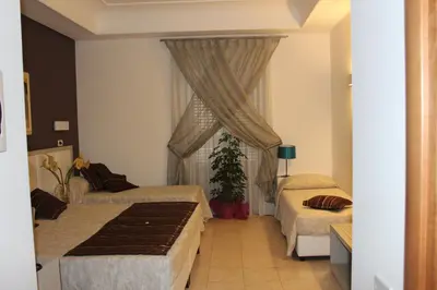 a hotel room with two beds and a window at Artemisia Palace Hotel in Palermo