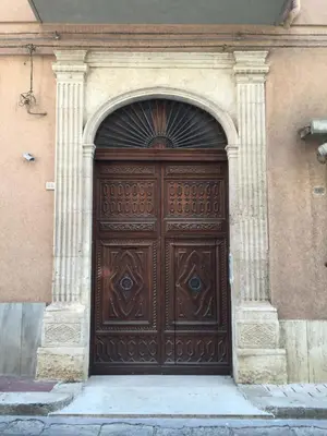 a large wooden door in the side of a building at Sui tetti b&b in Alcamo