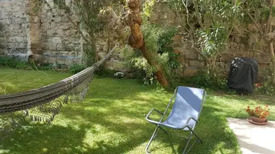 a hammock and a chair in a garden at Nel Giardino degli Agrumi in Palermo