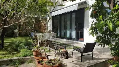 a patio with chairs and a table and some plants at Nel Giardino degli Agrumi in Palermo