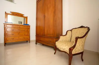 a bedroom with a dresser and a chair and a mirror at Appartamento Piazza Pretoria in Palermo