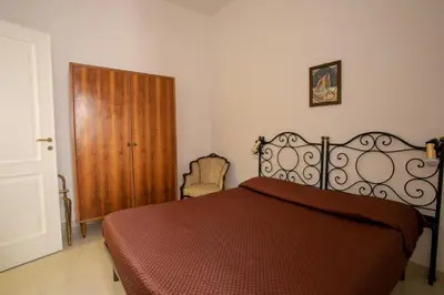 a bedroom with a bed and a wooden door at Appartamento Piazza Pretoria in Palermo