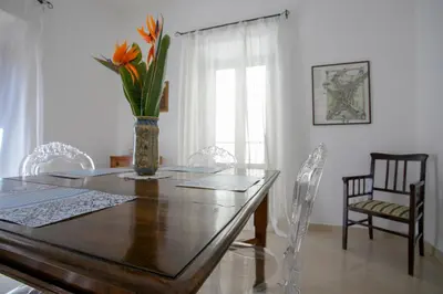 a dining room table with a vase of flowers on it at Appartamento Piazza Pretoria in Palermo