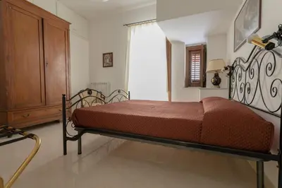 a bedroom with a bed and a wooden cabinet at Appartamento Piazza Pretoria in Palermo