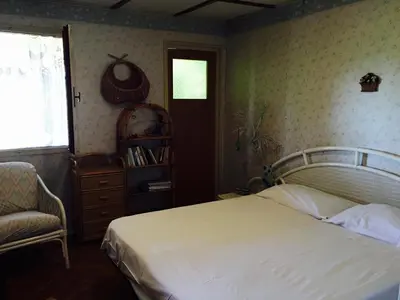 a bedroom with a bed and a chair and a window at Villa lo Iacono in Terrasini