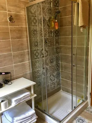 a shower with a glass door and some towels at Villa lo Iacono in Terrasini