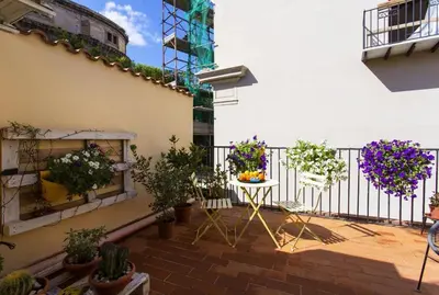 a balcony with potted plants and a table at BB4U Apartments and Terrace in Palermo