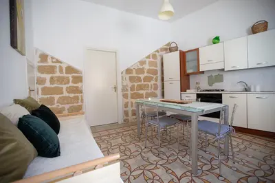 a living room with a table and a kitchen at Case di Maria in Castellammare del Golfo
