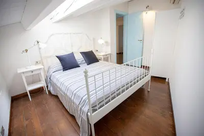 a white bed with blue pillows in a bedroom at Case di Maria in Castellammare del Golfo