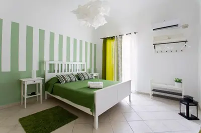 a bedroom with a bed with green and white stripes at Oasi Centrale in Palermo