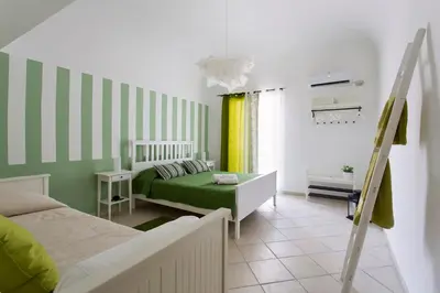 a bedroom with a green and white striped wall at Oasi Centrale in Palermo