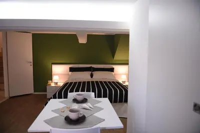 a bedroom with a bed and a table with two dishes on it at Chic Apartment Le Monde in Castellammare del Golfo