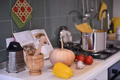 a kitchen counter with vegetables on a cutting board at Chic Apartment Le Monde in Castellammare del Golfo