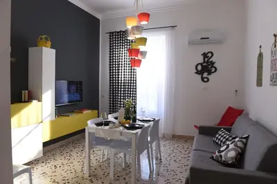 a living room with a table and a couch at Chic Apartment Le Monde in Castellammare del Golfo
