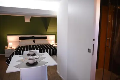 a bedroom with a bed and a white table with two cups at Chic Apartment Le Monde in Castellammare del Golfo