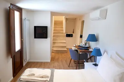 a bedroom with a bed and a desk and a staircase at Sopra Le Mura in Castellammare del Golfo