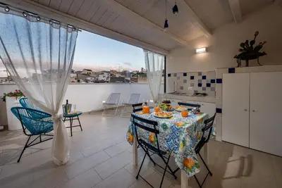 a kitchen with a table and chairs in a room at Le Perle del Golfo in Castellammare del Golfo