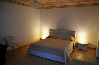 a bedroom with a bed and a chair and lights at Lercarappart in Lercara Friddi