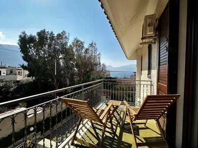 two chairs sitting on the balcony of a house at Garden House Alla Torre in Isola delle Femmine
