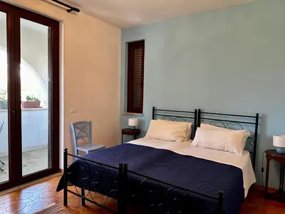 a bedroom with a bed with a blue blanket at Garden House Alla Torre in Isola delle Femmine