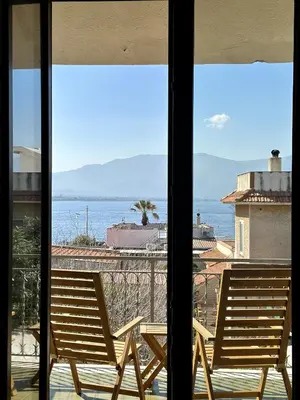 two chairs sitting on a balcony looking out at the ocean at Garden House Alla Torre in Isola delle Femmine